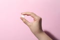 Woman holding pill on pink background, closeup Royalty Free Stock Photo