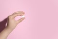 Woman holding pill on pink background, closeup. Space for text Royalty Free Stock Photo
