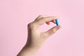 Woman holding pill on pink background, closeup Royalty Free Stock Photo