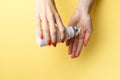 Woman holding pills on hand. Medicine and health care concept. Hand spilling pills for the pain of a bottle on yellow background Royalty Free Stock Photo