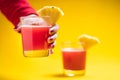 Woman holding Pineapple juice in glass closeup near sliced fruit with spash and dripping liqid for summer vibes