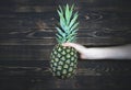 Woman holding Pineapple. Wooden background