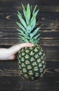 Woman holding Pineapple. Wooden background