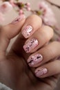 A woman holding a pink nail with cherry blossoms Royalty Free Stock Photo