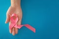 Woman holding pink ribbon on color background. Breast cancer concept Royalty Free Stock Photo