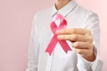 Woman holding pink ribbon on color background, closeup. Breast cancer awareness concept Royalty Free Stock Photo