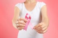 Woman holding pink ribbon on color background, closeup. Breast cancer awareness concept Royalty Free Stock Photo