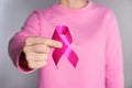 Woman holding pink ribbon on grey background, closeup Royalty Free Stock Photo