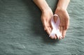 Woman holding pink ribbon on grey stone background, top view with space for text. Breast cancer awareness Royalty Free Stock Photo