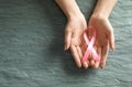 Woman holding pink ribbon on grey stone background, top view with space for text. Breast cancer awareness Royalty Free Stock Photo