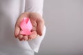 Woman holding pink ribbon on light background, closeup. Breast cancer awareness concept Royalty Free Stock Photo