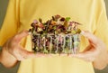 Woman holding plastic container with Red Rambo Radish Microgreens