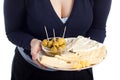 Woman holding plate with fresh olives and cheese