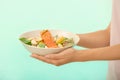 Woman holding plate with tasty salmon and fresh salad on color background Royalty Free Stock Photo