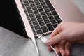 Woman holding plugged USB cable into laptop at grey table, closeup Royalty Free Stock Photo