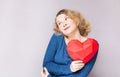 Woman holding polygonal diamond shaped red heart in front of her chest Royalty Free Stock Photo
