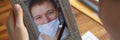 Woman holding portrait of deceased husband with improperly wearing protective medical mask closeup