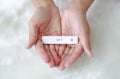 Woman holding positive pregnancy test in her palm on artificial white fur background Royalty Free Stock Photo