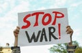 Woman holding poster with words Stop War against sky outdoors, closeup Royalty Free Stock Photo