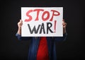 Woman holding poster with words Stop War on black background Royalty Free Stock Photo