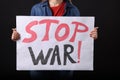 Woman holding poster with words Stop War on black background, closeup Royalty Free Stock Photo