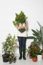 Woman holding potted orange tree over face