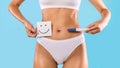 Woman holding pregnancy test and card with smiley face Royalty Free Stock Photo
