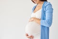 Woman holding pregnant belly against white background Royalty Free Stock Photo