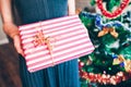 Woman holding present box near Christmas tree Royalty Free Stock Photo