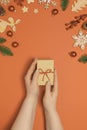 Woman holding present box on orange table Royalty Free Stock Photo