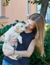 Woman is holding a puppy dog breed Labrador