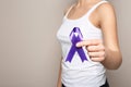 Woman holding purple ribbon on grey background, closeup. Domestic violence awareness Royalty Free Stock Photo