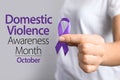 Woman holding purple ribbon on background, closeup. Symbol of Domestic Violence Awareness