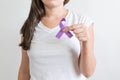 Woman holding a purple ribbon of the International Day for the Elimination of Violence Against Women