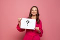 Woman holding question mark sign on pink background Royalty Free Stock Photo