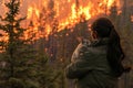 woman holding rabbit, watching forest ablaze