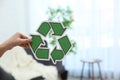 Woman holding recycling symbol on blurred background, closeup Royalty Free Stock Photo