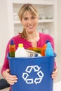 Woman Holding Recyling Waste Bin At Home