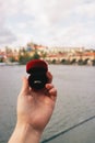 Woman holding a red box with engagement ring front The Charles Bridge. An offer of marriage in Prague, Czech Republic. Royalty Free Stock Photo