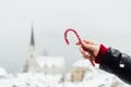 Woman holding red candycane with Hallstatt old town on background, Austria