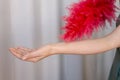 A woman is holding a red feather fan laser hair removal concept Royalty Free Stock Photo