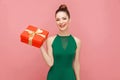 Woman holding red gift box and toothy smiling Royalty Free Stock Photo