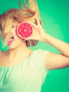 Woman holding red grapefruit having crazy windblown hair Royalty Free Stock Photo