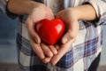 Woman holding red heart in hands, closeup