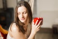 Woman holding red mug of coffee