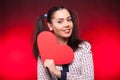 Woman holding a red papper heart in hands