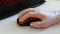 Woman is holding red stylish mouse by her hand, close up. Doctor or nurse or office worker using protective gloves while Royalty Free Stock Photo