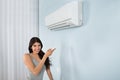 Woman holding remote control air conditioner