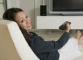 Woman Holding Remote Control While Sitting On Chair Royalty Free Stock Photo