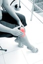 Woman holding right knee with both hands while sitting down to show pain in the knee